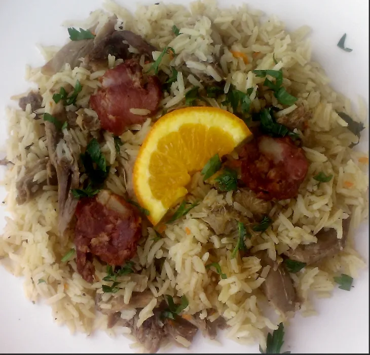 Arroz com enchidos e uma rodela de laranja