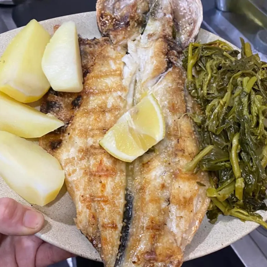 Peixe grelhado aberto, com batata cozida e grelos