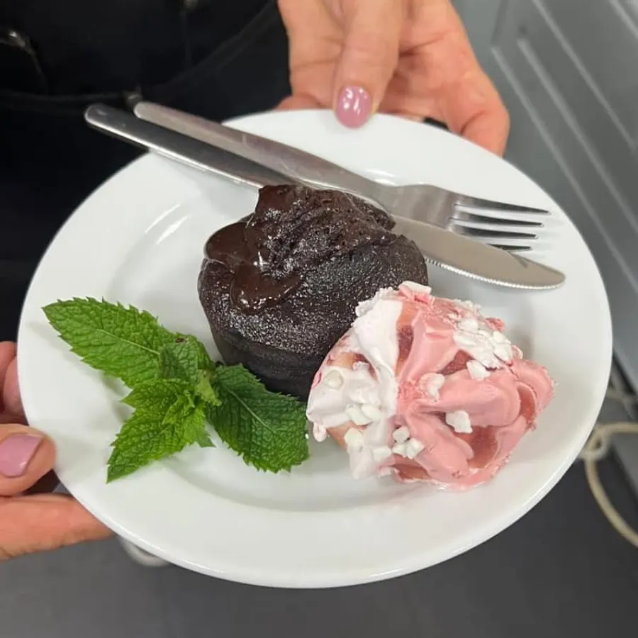 Uma sobremesa de chocolate com gelado e hortelã